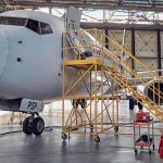 side-view-image-big-white-passenger-aircraft-standing-parking-apron-aviation-hangar-image